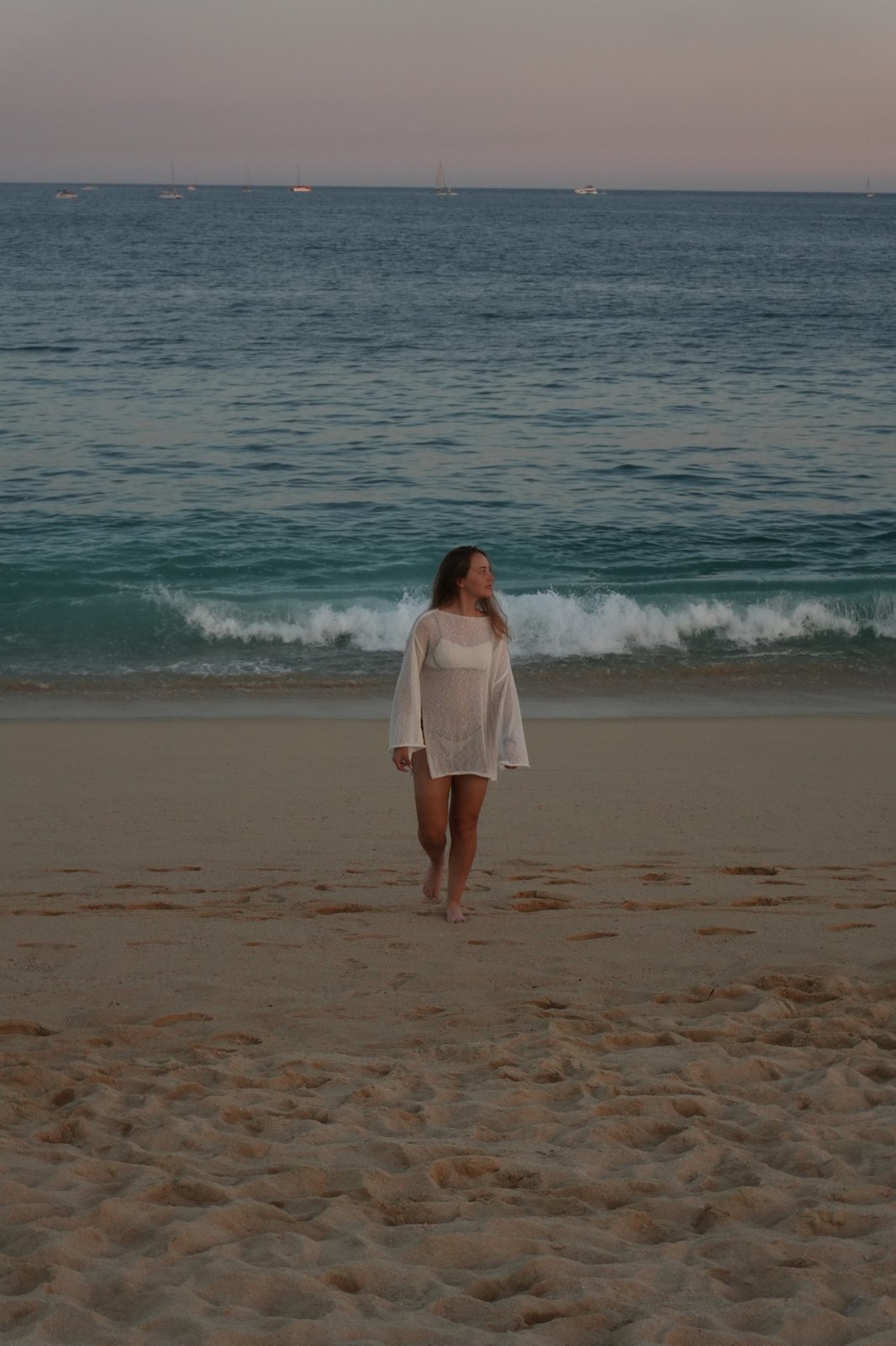 Modelo caminando en la playa al atardecer, colección Mar y Tierra
