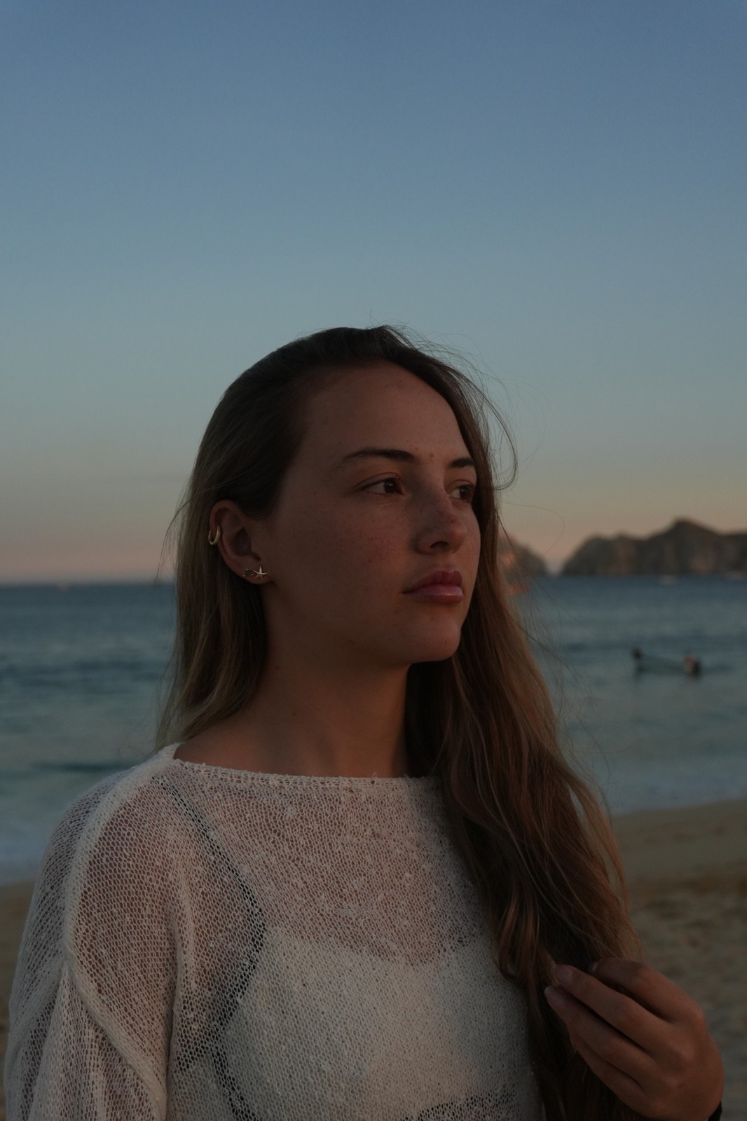 Modelo en la playa al atardecer con arete LAUVE, colección Mar y Tierra