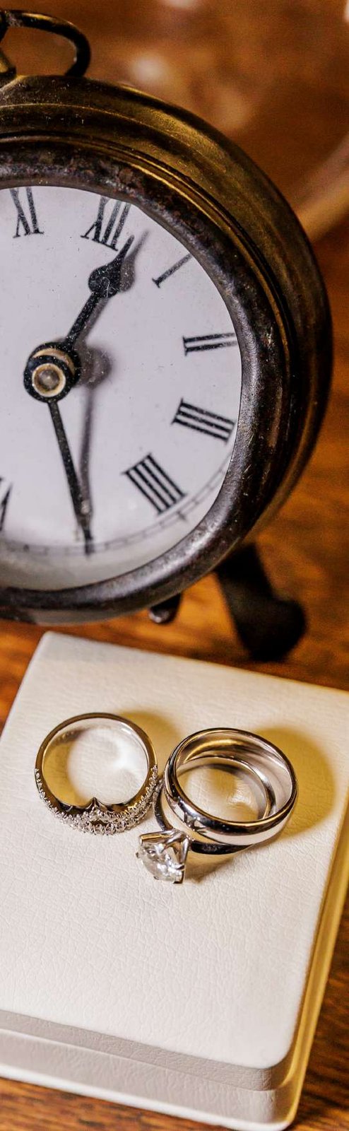 Argollas de matrimonio junto a un reloj antiguo